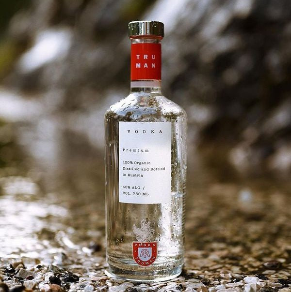 Bottle of Truman Vodka on a textured surface with a blurred natural background