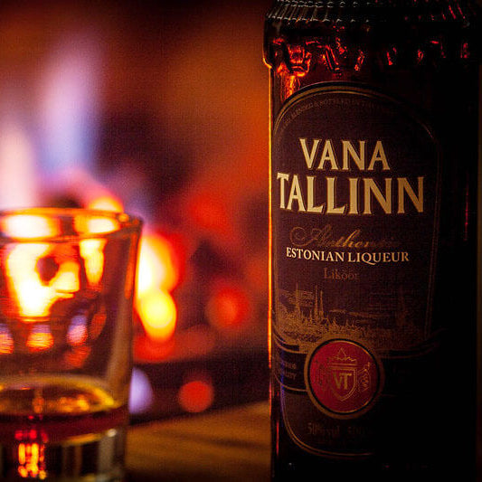 Vana Tallinn Estonian liqueur bottle with a glass in front of a warm, blurred background