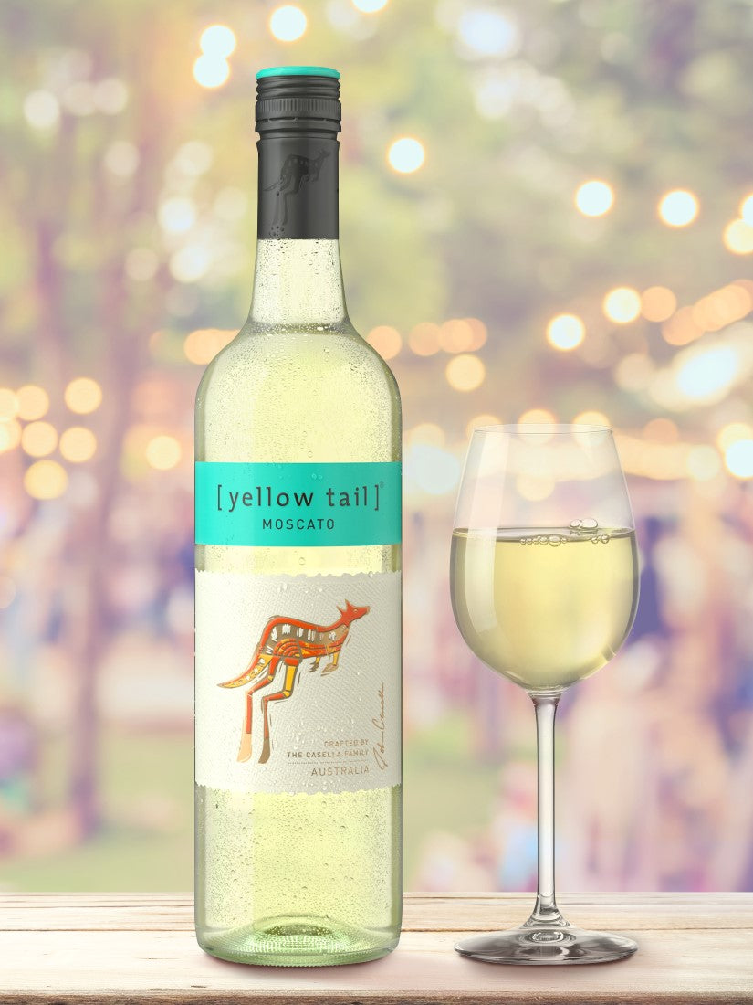 Yellow Tail Moscato wine bottle with a glass of wine on a blurred outdoor background