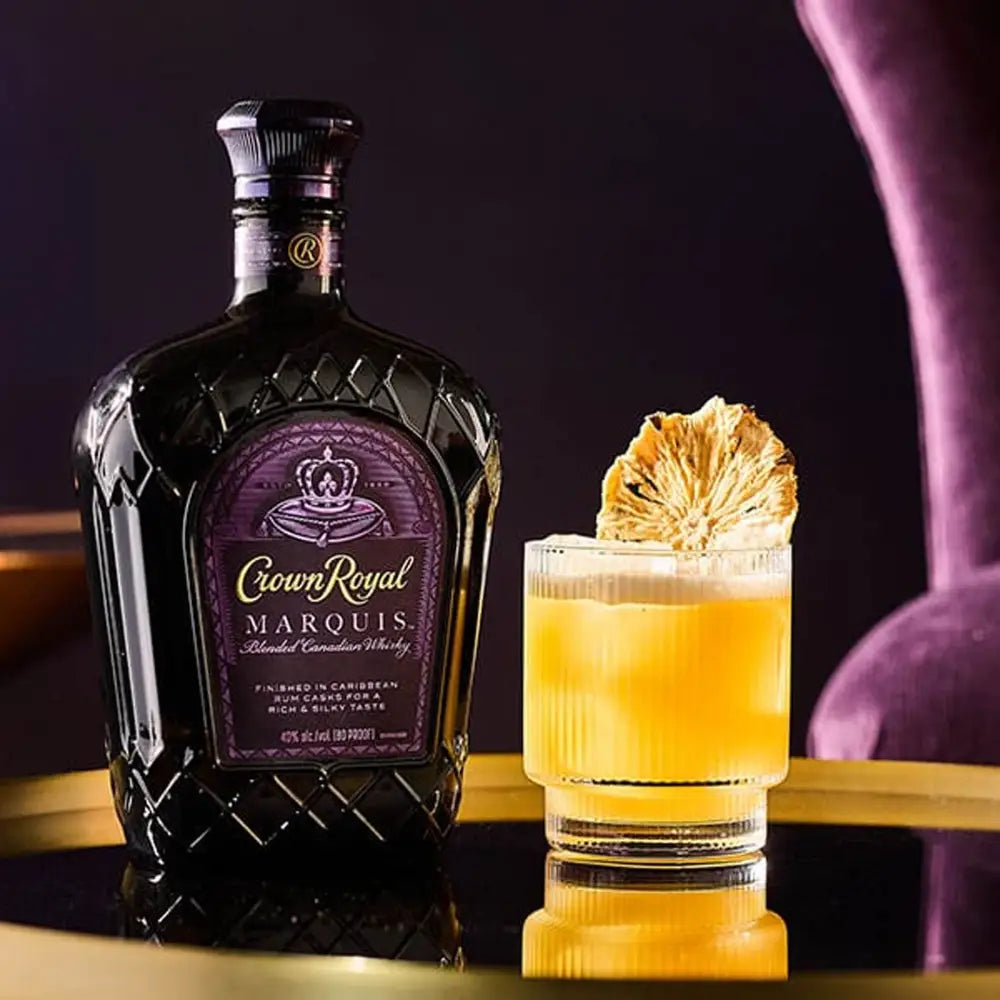 Crown Royal Marquis whiskey bottle with a cocktail on a dark background