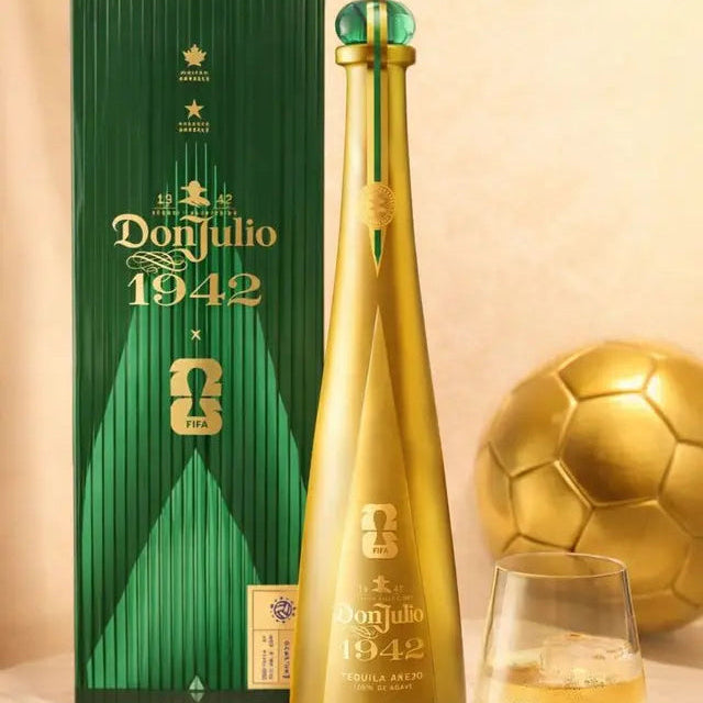 Don Julio 1942 bottle and packaging with a glass of white wine on a beige background