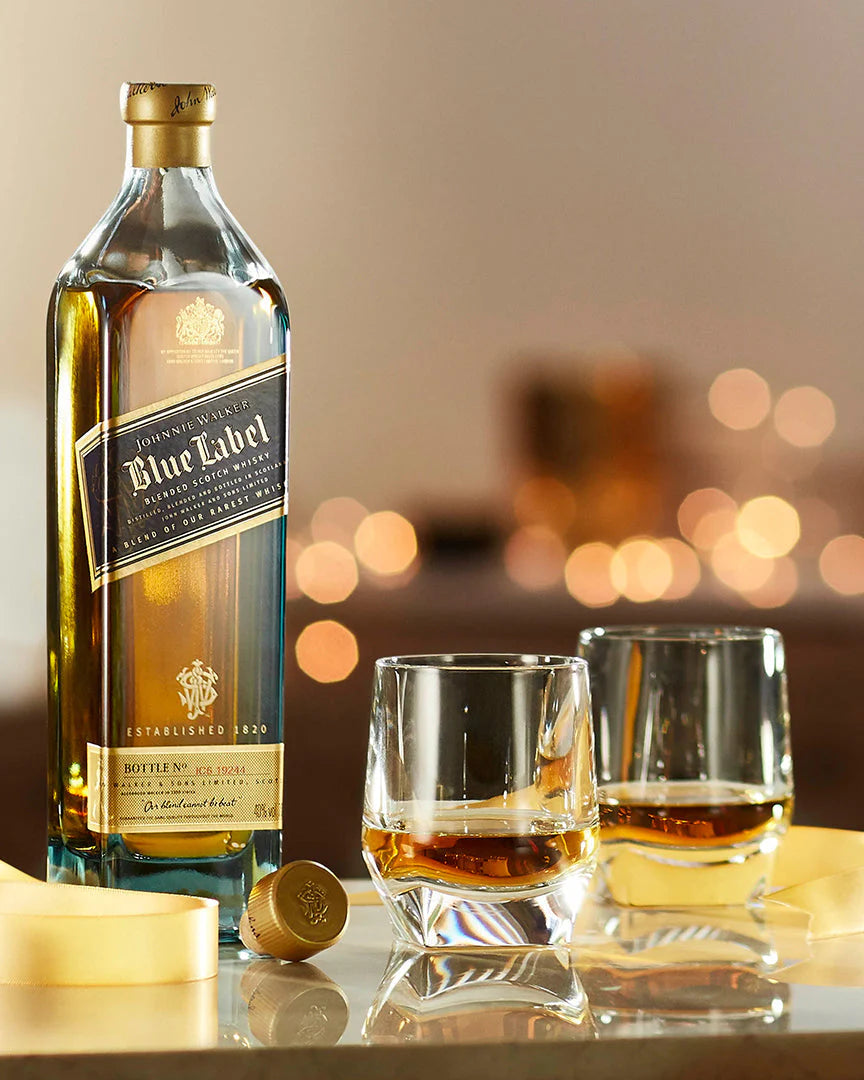 Johnnie Walker Blue Label bottle with two whisky glasses on a marble table, premium Scotch whisky ideal for gifting, luxury celebrations, and elegant sipping moments