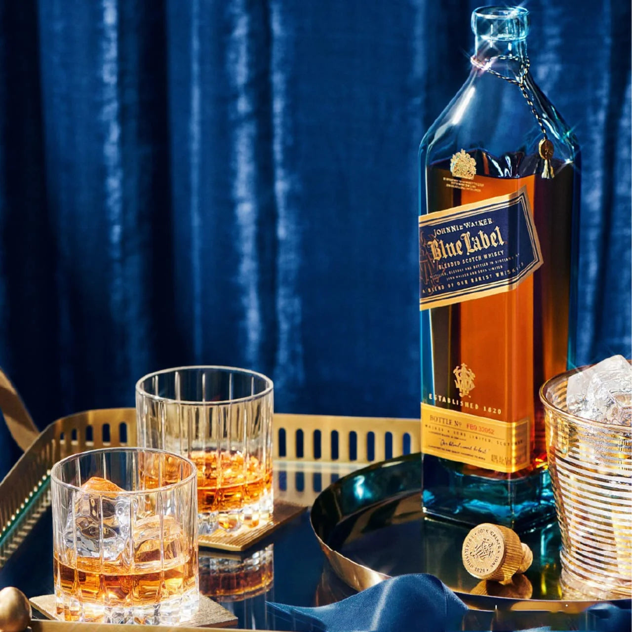 Johnnie Walker Blue Label served on the rocks in crystal glasses with premium 750ml bottle, luxury Scotch whisky experience with rich flavor and elegant presentation