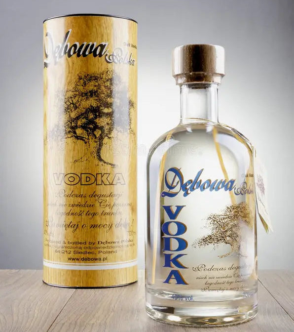 Debowa Vodka bottle and cylindrical container on a wooden surface with a gray background