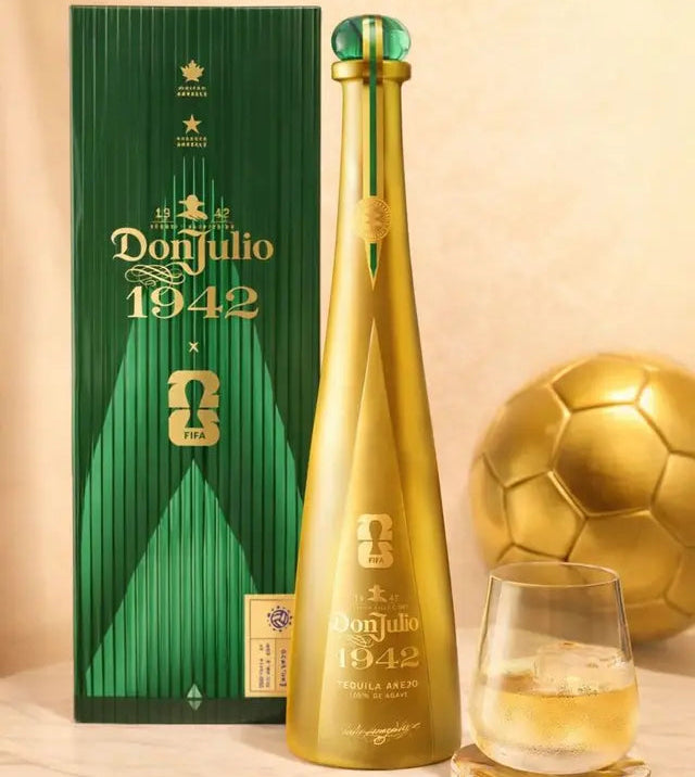 Don Julio 1942 bottle and packaging with a glass of white wine on a beige background