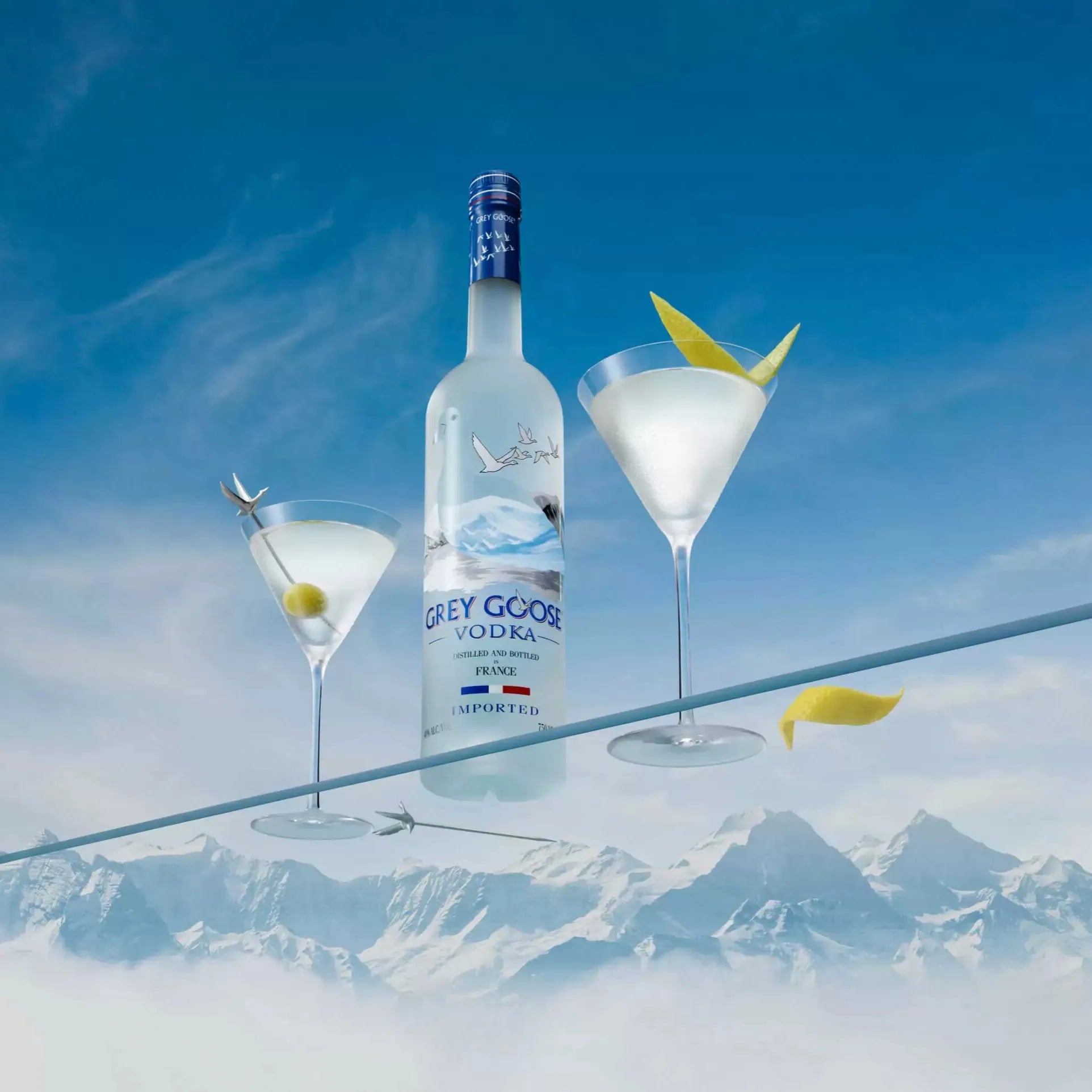 Grey Goose Vodka Martini Cocktail served with lemon twist garnish against a mountain skyline backdrop