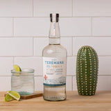 Teremana Blanco Tequila bottle on counter with glass of tequila and lime garnish, premium small batch tequila handcrafted in Mexico.
