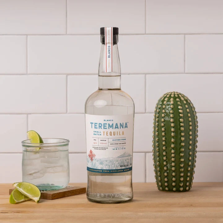 Teremana Blanco Tequila bottle on counter with glass of tequila and lime garnish, premium small batch tequila handcrafted in Mexico.